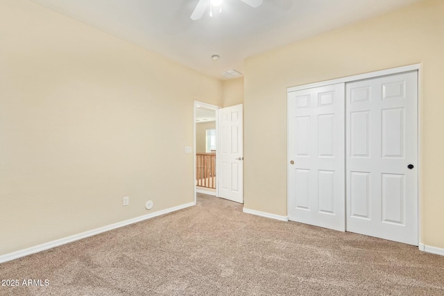 unfurnished bedroom featuring ceiling fan, a closet, and carpet