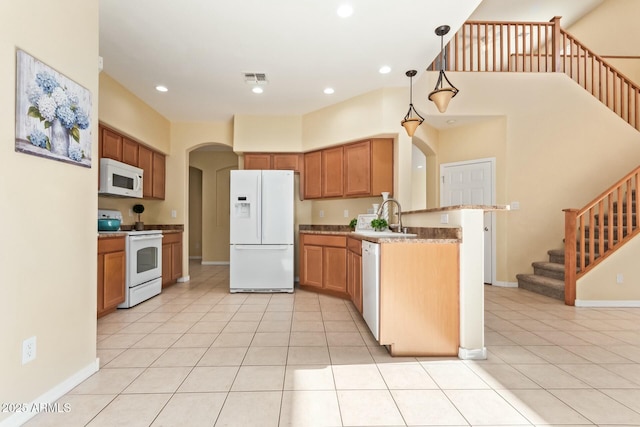 kitchen featuring light tile patterned flooring, pendant lighting, sink, kitchen peninsula, and white appliances