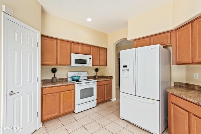 kitchen featuring light tile patterned flooring and white appliances