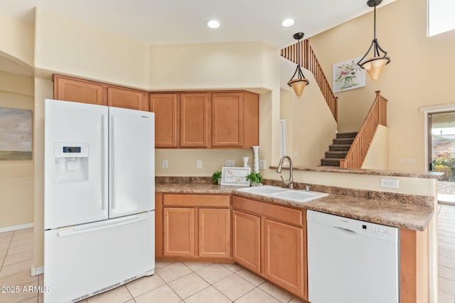 kitchen with pendant lighting, sink, white appliances, light tile patterned floors, and kitchen peninsula