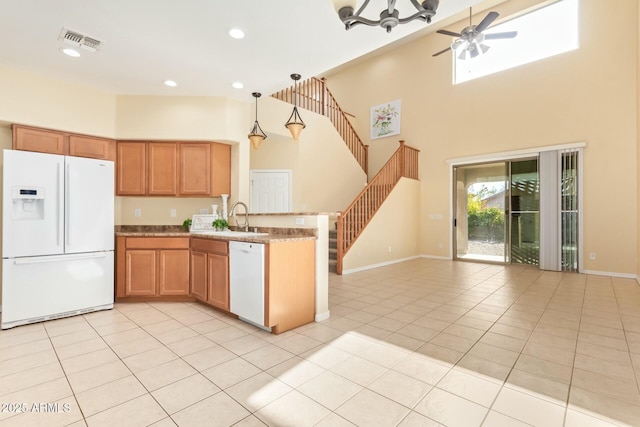 kitchen with white appliances, sink, hanging light fixtures, and light tile patterned floors