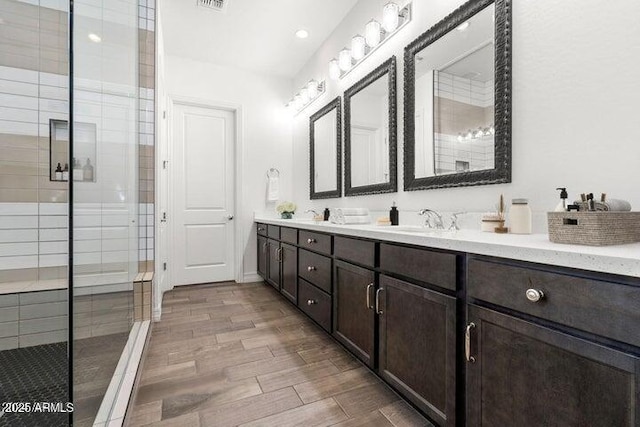 11249 N Blakely St, Surprise, AZ 85388 - bathroom featuring double vanity, wood finished floors, a stall shower, and recessed lighting