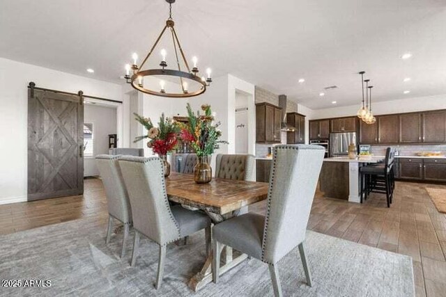 11249 N Blakely St, Surprise, AZ 85388 - dining room featuring a barn door, a chandelier, light wood-type flooring, and recessed lighting