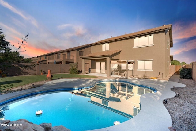 pool at dusk featuring a patio area