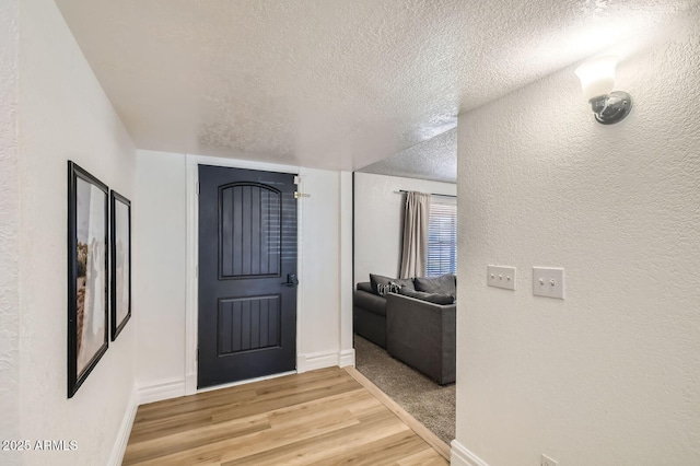 624 N Ashbrook Cir, Mesa, AZ 85213 - foyer with a textured ceiling, light wood-style flooring, a textured wall, and baseboards