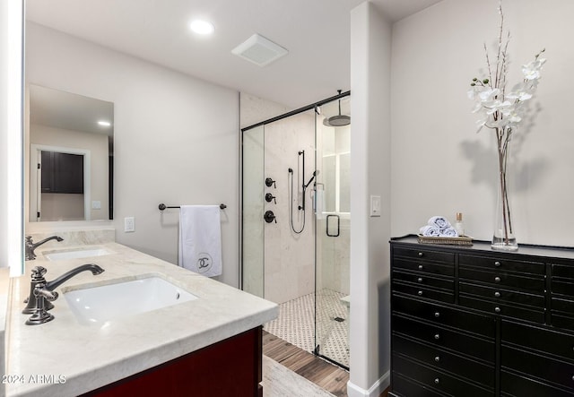 bathroom with hardwood / wood-style flooring, vanity, and a shower with shower door