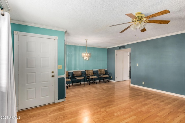 living room featuring ceiling fan, crown molding, light wood-type flooring, and a textured ceiling