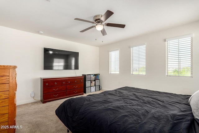 bedroom with light colored carpet, baseboards, and ceiling fan