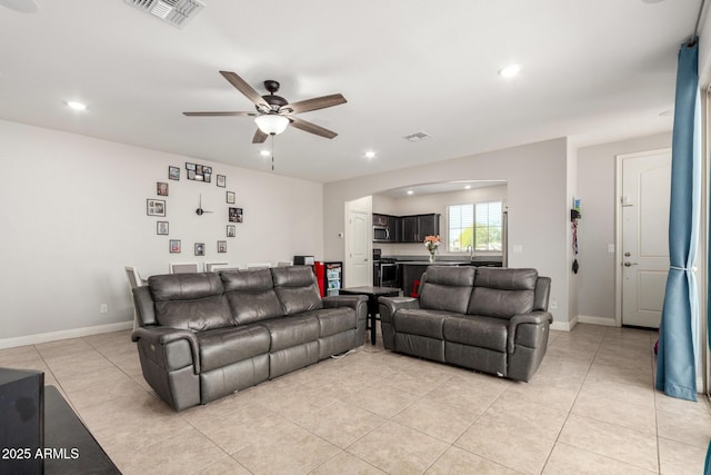 living room with a ceiling fan, light tile patterned flooring, arched walkways, recessed lighting, and baseboards