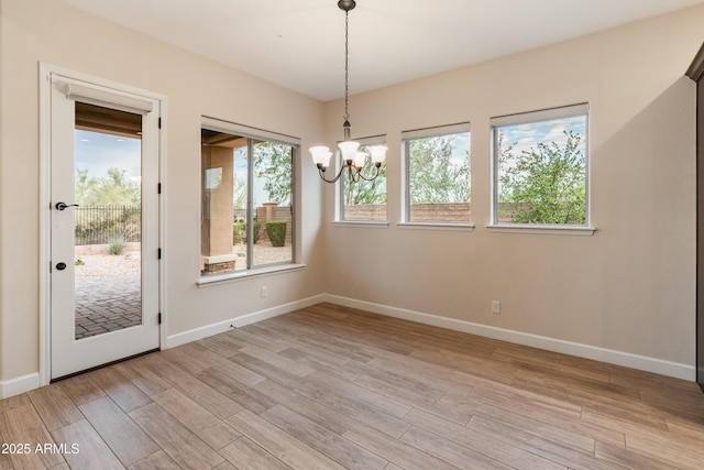 31207 N 124th Dr, Peoria, AZ 85383 - unfurnished dining area featuring light wood-style floors, a chandelier, and baseboards
