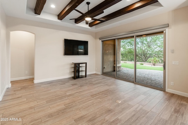 31207 N 124th Dr, Peoria, AZ 85383 - unfurnished living room featuring ceiling fan, beam ceiling, arched walkways, light wood-style flooring, and baseboards