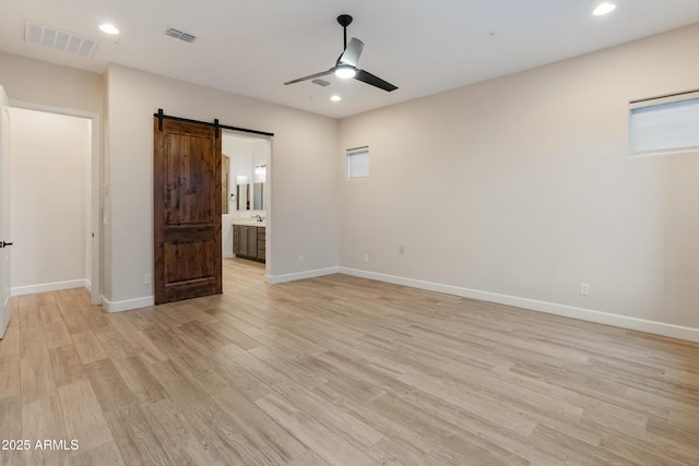 31207 N 124th Dr, Peoria, AZ 85383 - empty room featuring a barn door, a ceiling fan, light wood-type flooring, baseboards, and recessed lighting