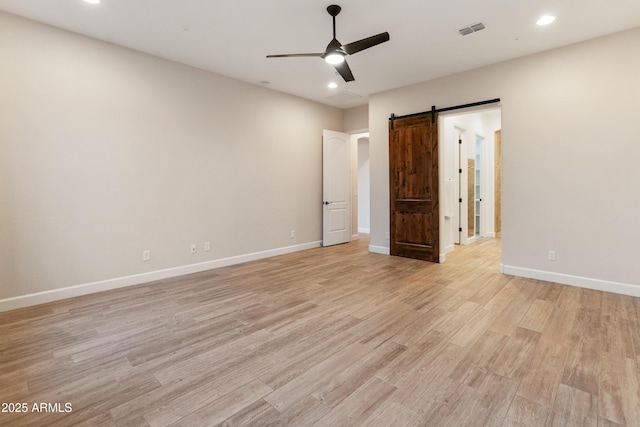 31207 N 124th Dr, Peoria, AZ 85383 - unfurnished bedroom featuring a barn door, light wood finished floors, recessed lighting, baseboards, and a ceiling fan