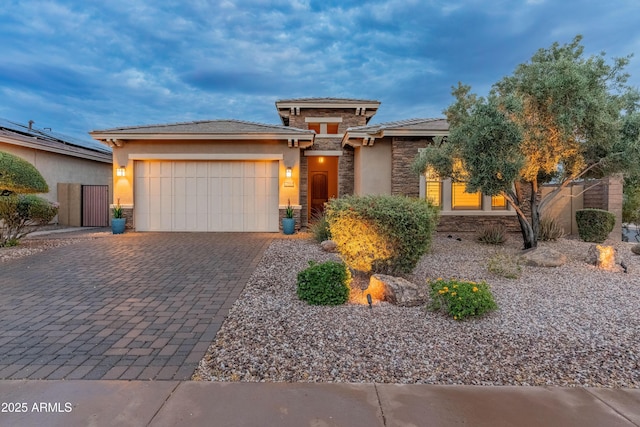 31207 N 124th Dr, Peoria, AZ 85383 - prairie-style house with stone siding, a garage, decorative driveway, stucco siding, and a tiled roof