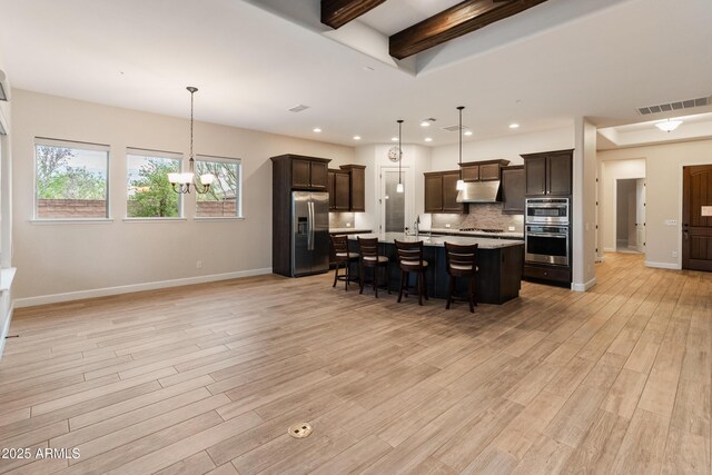 31207 N 124th Dr, Peoria, AZ 85383 - kitchen with appliances with stainless steel finishes, under cabinet range hood, light countertops, a chandelier, and dark brown cabinets
