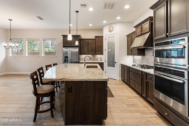 31207 N 124th Dr, Peoria, AZ 85383 - kitchen featuring stainless steel appliances, a sink, a chandelier, under cabinet range hood, and light wood finished floors