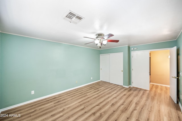 unfurnished bedroom featuring crown molding, light wood-type flooring, and ceiling fan