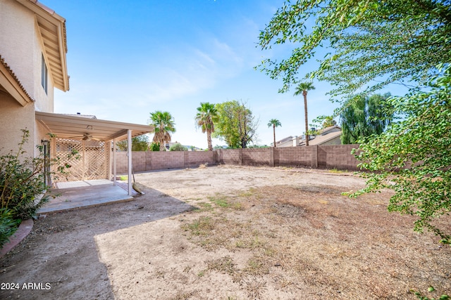 view of yard with ceiling fan and a patio area