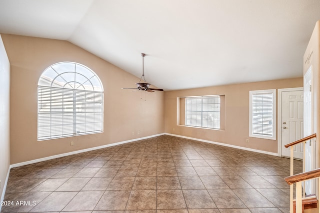 empty room with ceiling fan, lofted ceiling, plenty of natural light, and tile patterned flooring