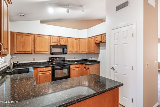 kitchen featuring lofted ceiling, black appliances, dark stone counters, and sink