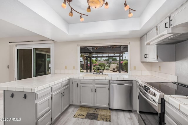 1549 N La Rosa Dr, Tempe, AZ 85288 - kitchen featuring stainless steel appliances, a peninsula, light wood finished floors, and range hood