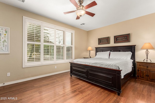 bedroom with visible vents, ceiling fan, baseboards, and wood finished floors