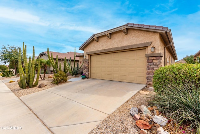 view of front of house featuring a garage, stone siding, driveway, and stucco siding