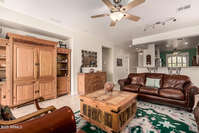 living area with a ceiling fan, visible vents, and light tile patterned flooring