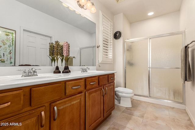 full bathroom featuring a sink, a shower stall, toilet, and double vanity