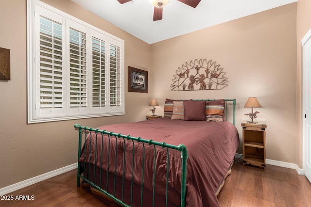 bedroom with wood finished floors, a ceiling fan, and baseboards