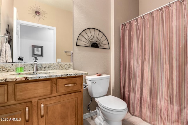 full bath featuring a textured wall, a shower with shower curtain, vanity, and toilet