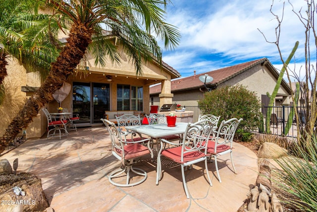 view of patio / terrace featuring a ceiling fan, outdoor dining space, and fence