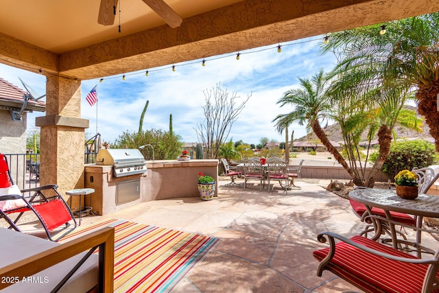 view of patio / terrace with a ceiling fan, area for grilling, a grill, fence, and outdoor dining space