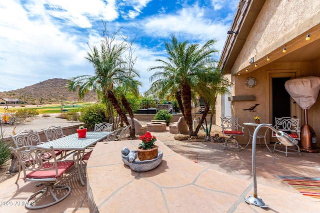 view of patio / terrace with outdoor dining area and a mountain view