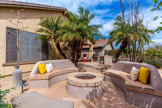 view of patio / terrace with exterior kitchen, grilling area, and an outdoor living space with a fire pit