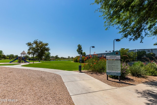 view of home's community featuring playground community and a yard