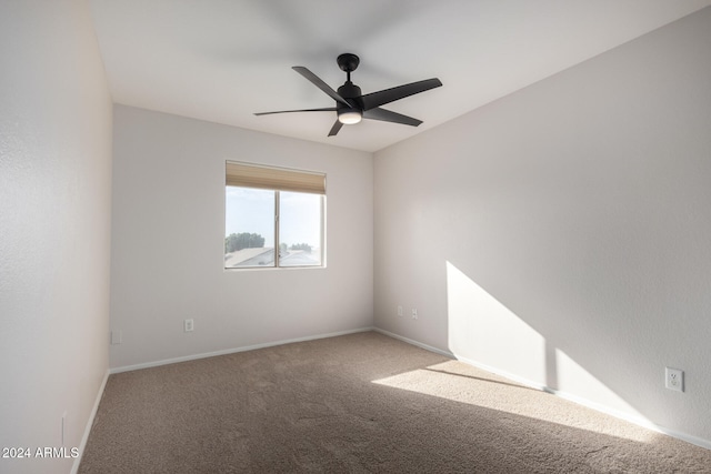 carpeted spare room with ceiling fan