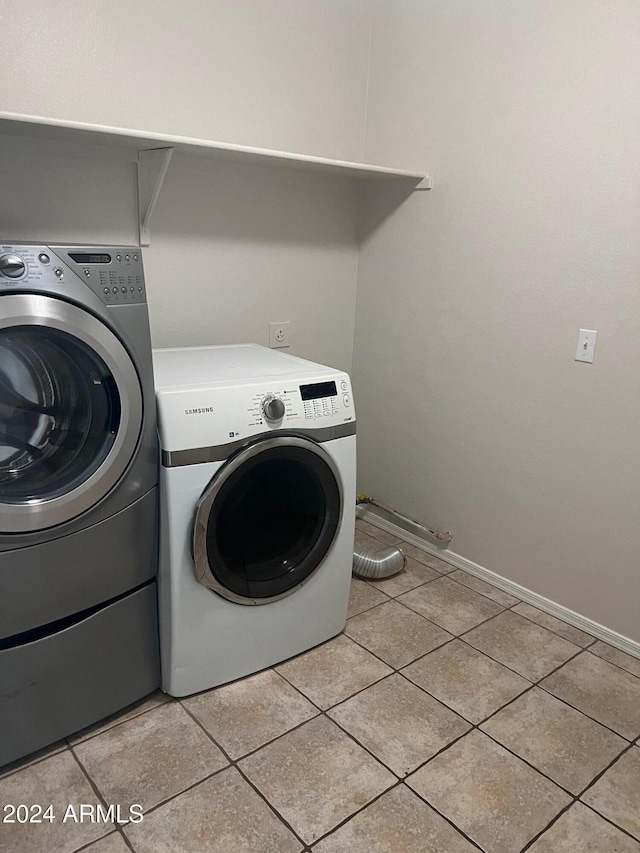 washroom featuring light tile patterned floors and washing machine and clothes dryer