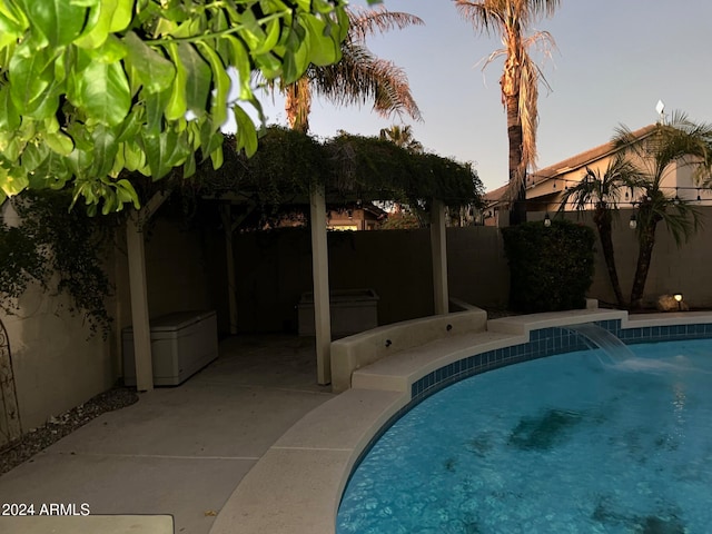 pool at dusk with pool water feature