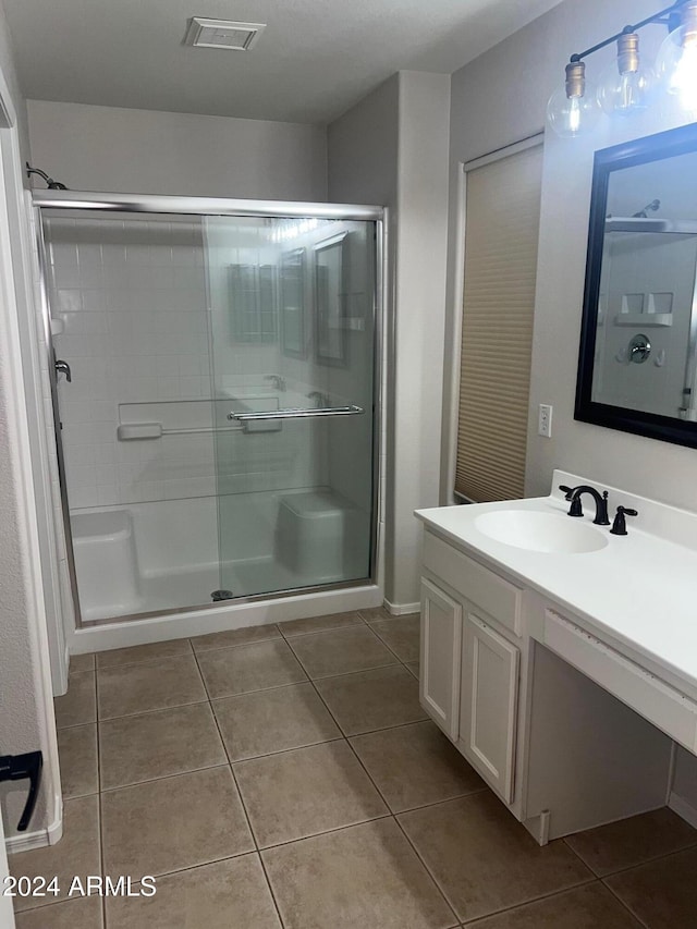 bathroom with tile patterned flooring, vanity, and a shower with shower door