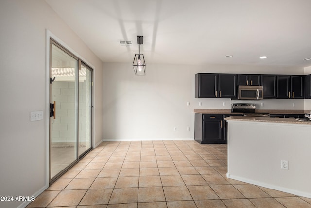 kitchen featuring pendant lighting, light tile patterned flooring, and stainless steel appliances