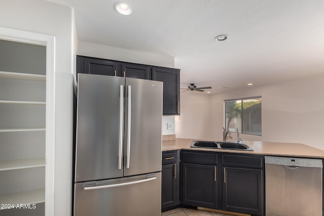 kitchen featuring sink, ceiling fan, light tile patterned floors, kitchen peninsula, and stainless steel appliances