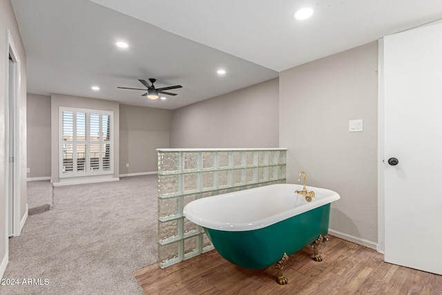 bathroom featuring a bath, ceiling fan, and hardwood / wood-style floors