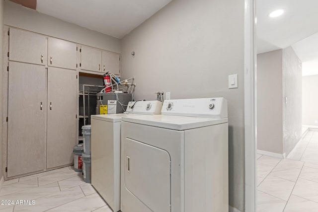 laundry room with electric water heater and washing machine and clothes dryer