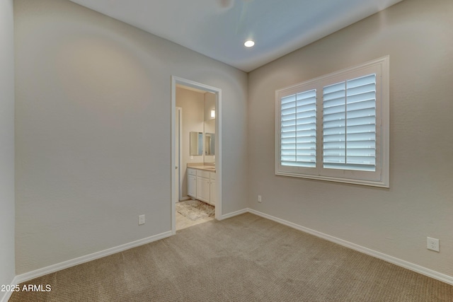 empty room featuring light carpet and baseboards