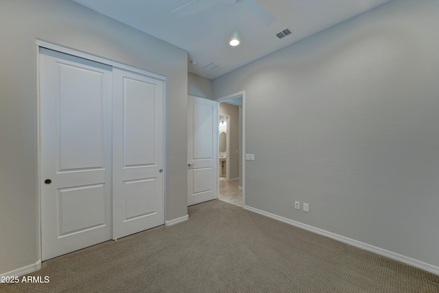 unfurnished bedroom with baseboards, visible vents, a closet, and light colored carpet