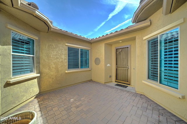 entrance to property with a patio area and stucco siding