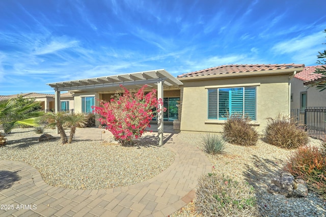 view of front of property featuring a patio area, stucco siding, fence, and a pergola