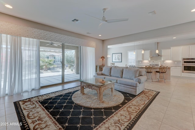 living room featuring light tile patterned floors, visible vents, a ceiling fan, and recessed lighting