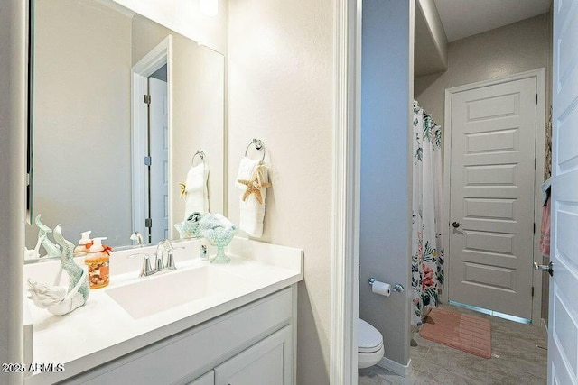 bathroom with vanity, curtained shower, and toilet